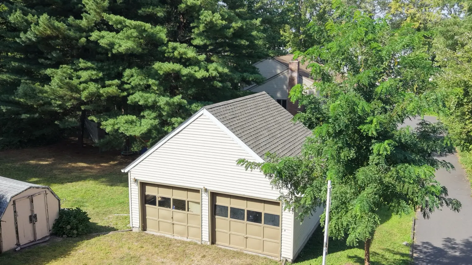 The detached garage with its completed shingle roof.