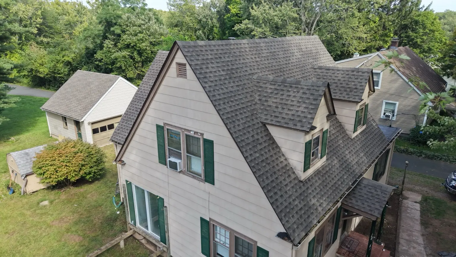 Completed steep roof on a church-owned residence in Enfield, with the garage behind it