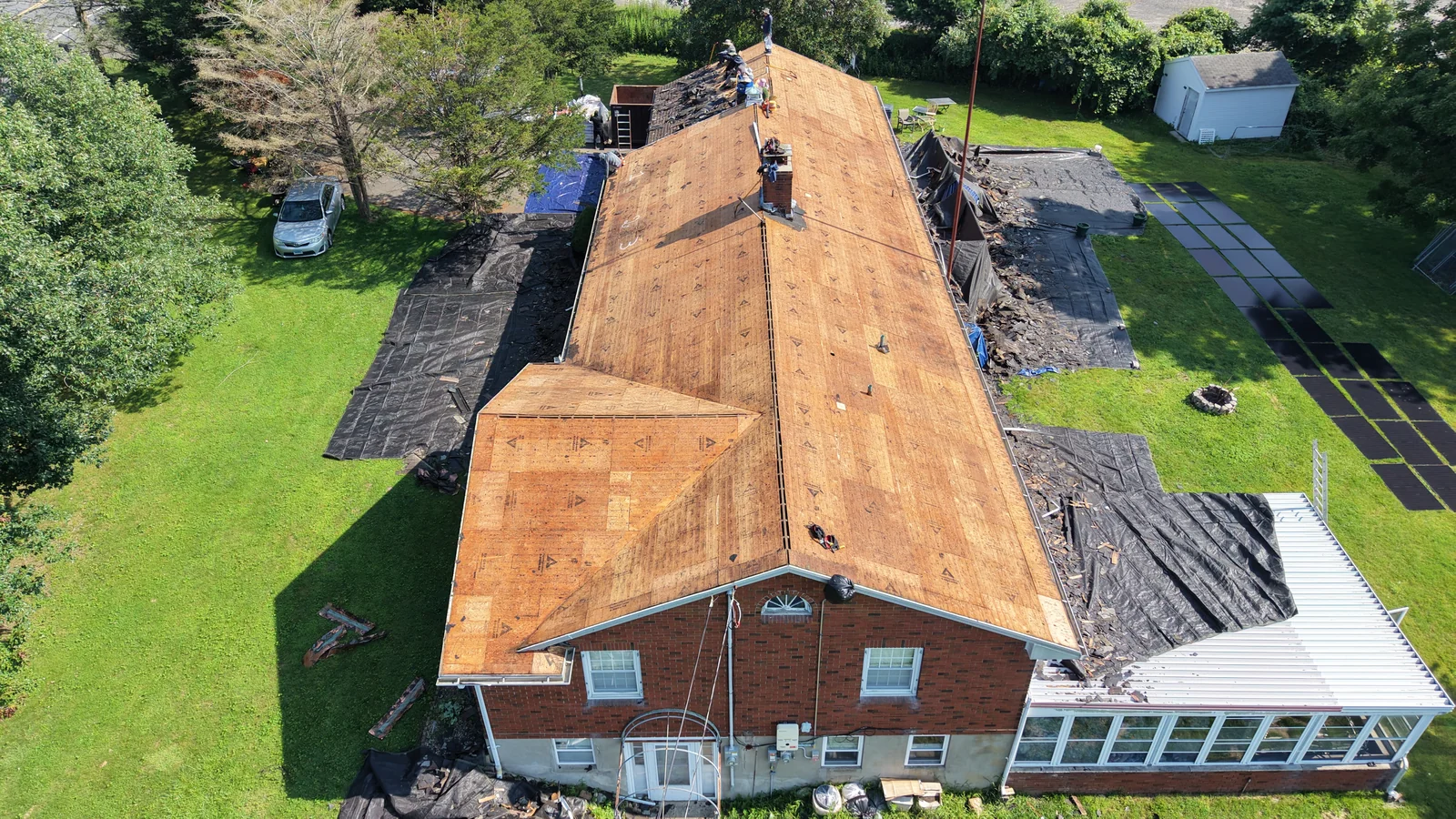 The exposed roof deck on a brick home during roof replacement
