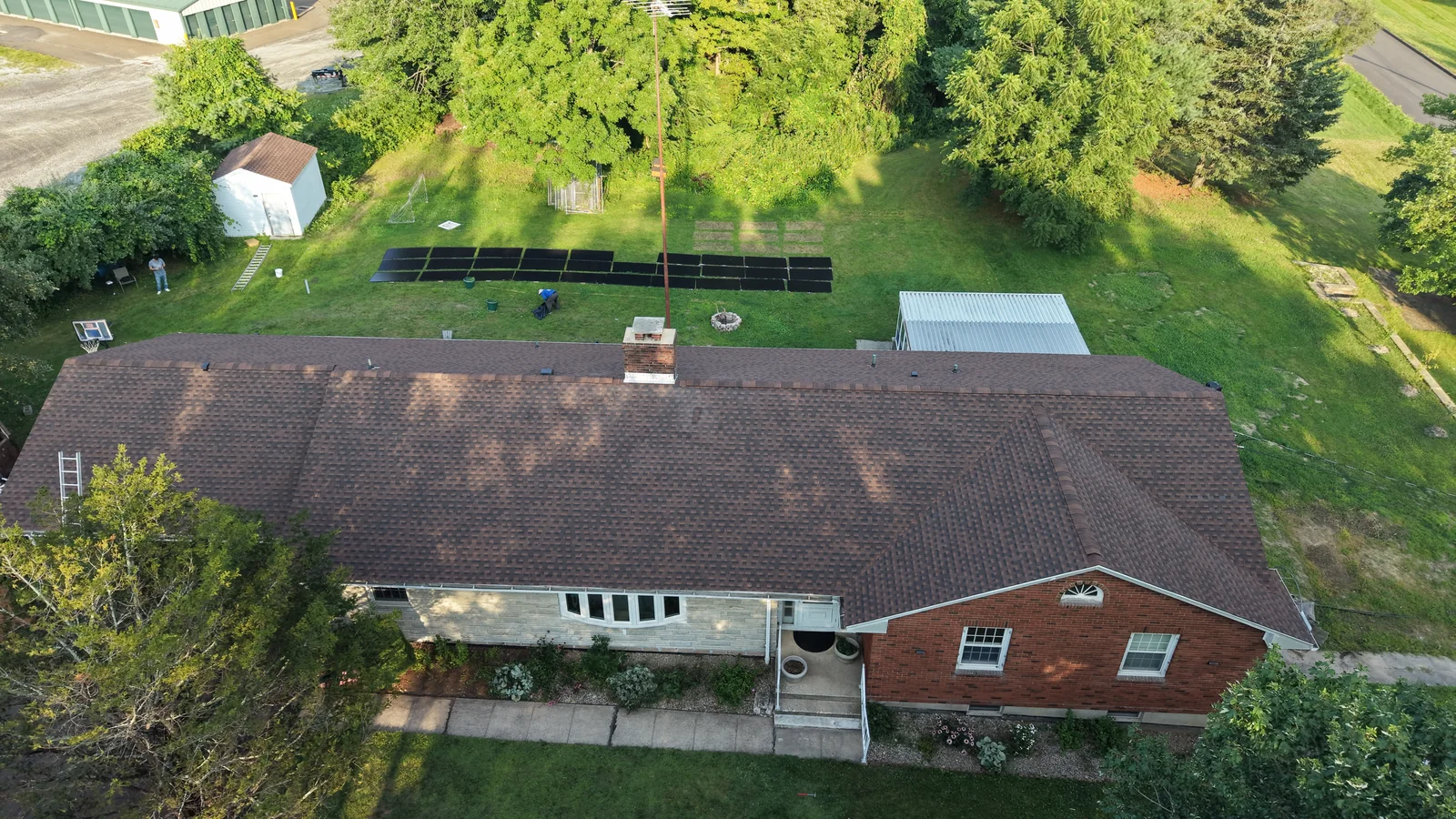The same brick home with its new shingles installed